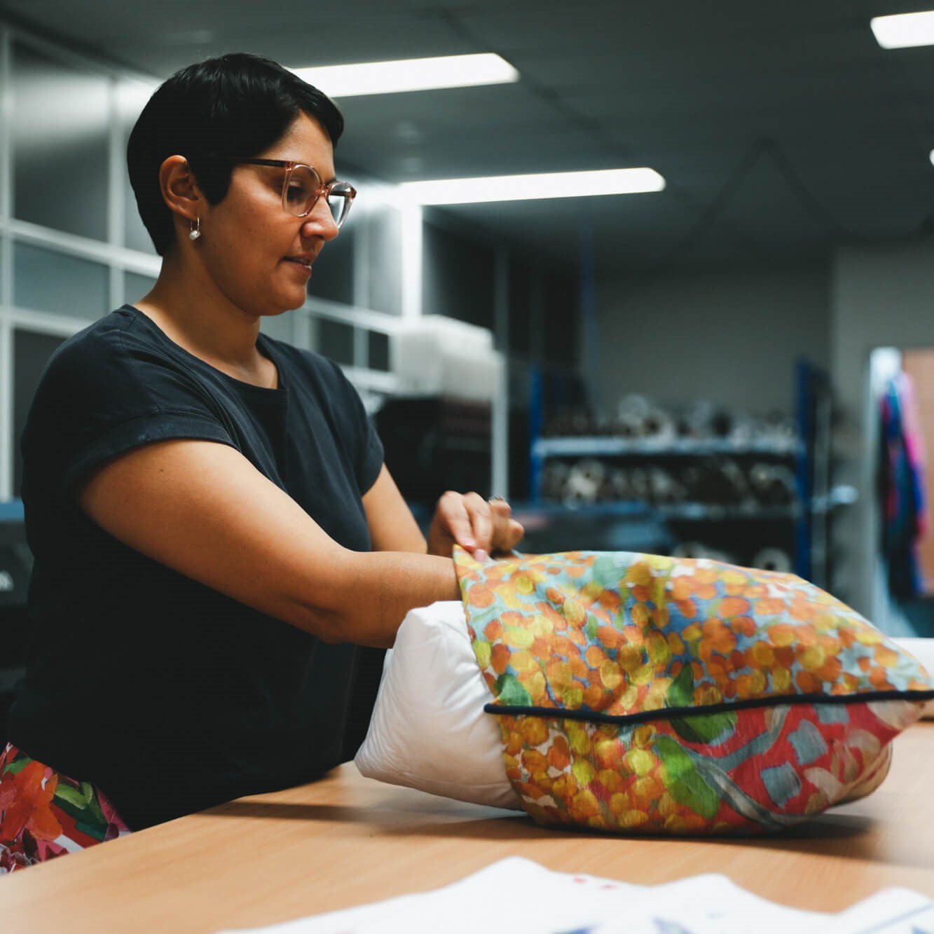 Rameez from APPLiK stuffing a custom-made cushion cover with a cushion insert.
