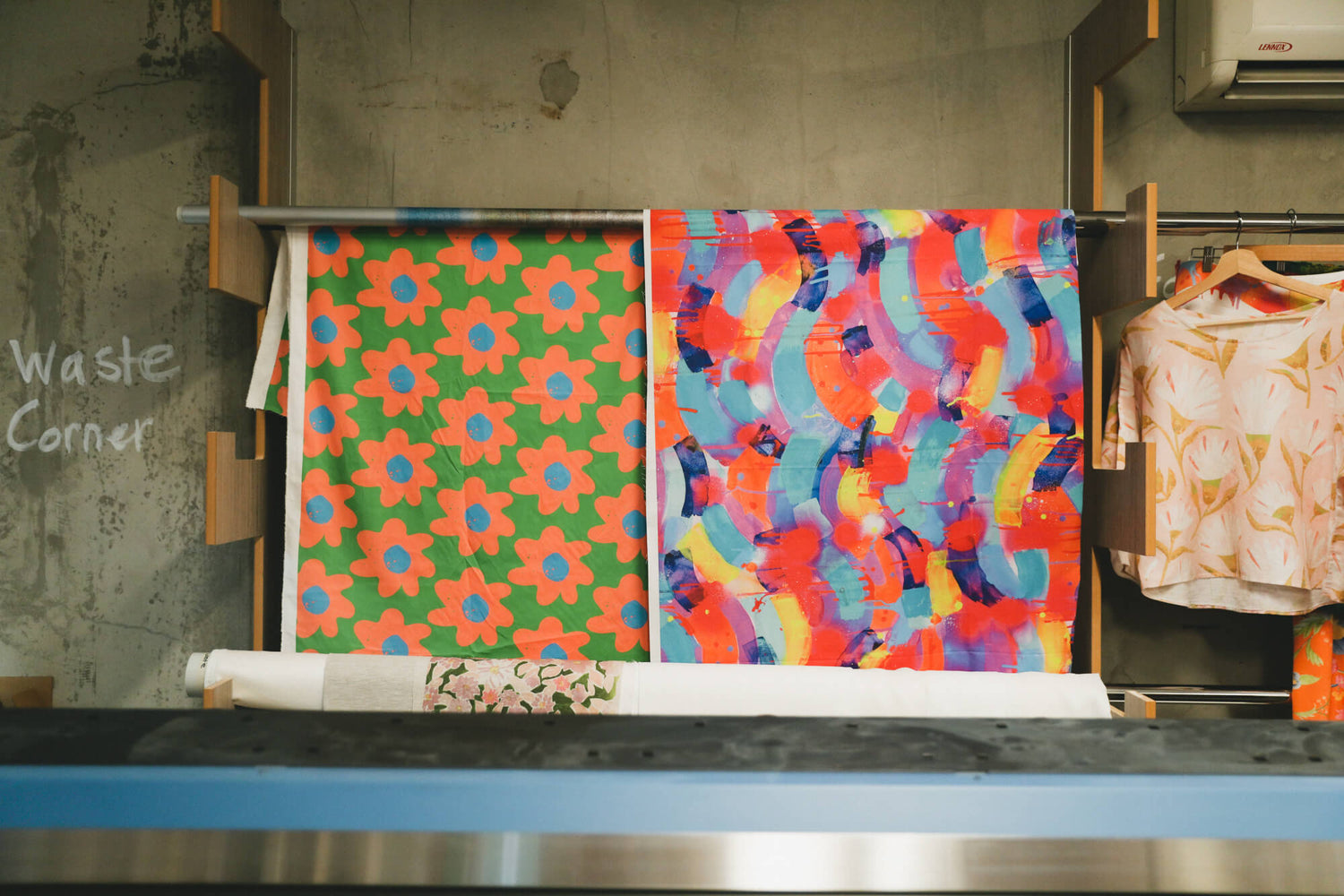 Two bright fabrics hanging in the APPLiK printing studio.
